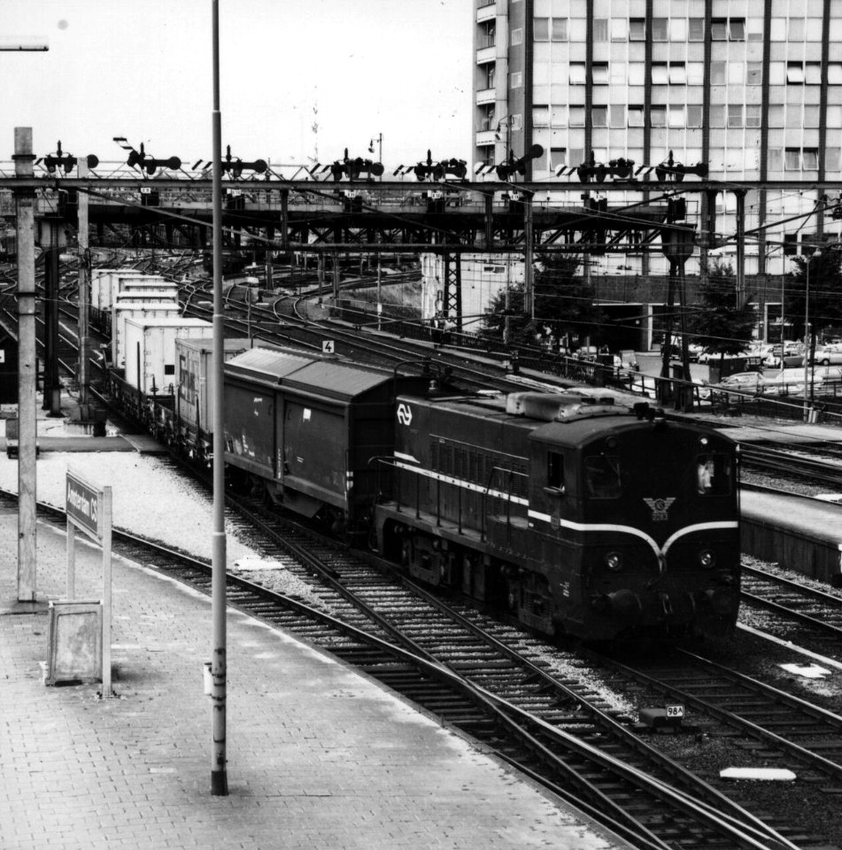 HUA-159886-Afbeelding van de diesel-electrische locomotief nr. 2283 (serie 2200-2300) van de N.S. met een goederentrein op het emplacement aan de westzijde van het N.S.-station Amsterdam C.S. te Amsterdam