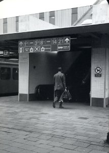 HUA-170765-Afbeelding van de toegang naar de roltrappen op één van de perrons van het N.S.-station Utrecht C.S., met pictogrammen in de nieuwe huisstijl