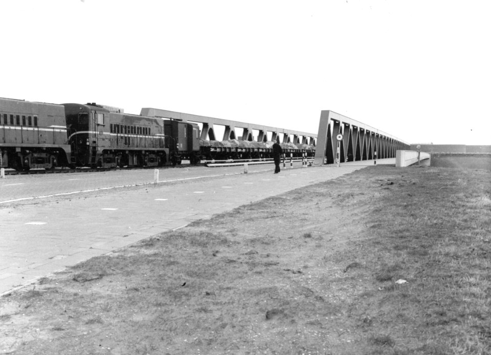 HUA-171036-Afbeelding van een goederentrein met stenen, getrokken door twee diesel-electrische locomotieven uit de serie 2200-2300 van de N.S. op de Dintelhavenbrug ten behoeve van de aanleg van de Europoorthave