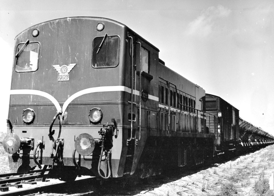 HUA-171023-Afbeelding van de diesel-electrische locomotief nr. 2256 (serie 2200-2300) van de N.S. met een zandtrein teTer Heijde ten behoeve van de versterking van de zeewering