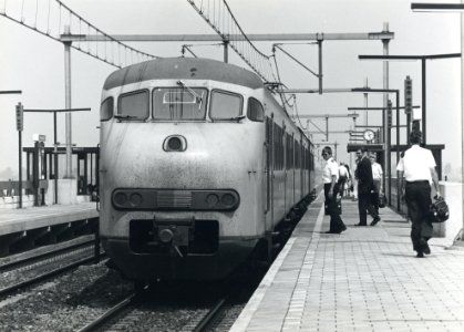 HUA-170798-Afbeelding van een electrisch treinstel plan T (mat. 1964) van de N.S. langs het perron van het N.S.-station Nieuw Vennep