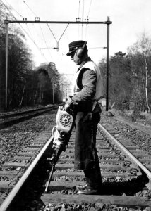 HUA-169035-Afbeelding van een wegwerker van de N.S. met een trilstand tijdens onderhoudswerkzaamheden aan de spoorlijn nabij Driebergen-Zeist