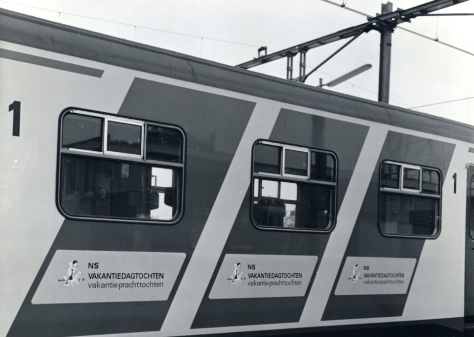 HUA-170707-Afbeelding van de blauwe, diagonale reclamebanden met reclame voor NS Vakantiedagtochten op de zijwand van een electrisch treinstel plan V (mat. 1964) van de N.S. te Alphen aan den Rijn tijdens de int