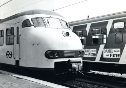 HUA-170710-Afbeelding van de introductie van de nieuwe, gele huisstijl van de electrische treinstellen mat. 1964 (plan V) van de N.S. op het traject Utrecht-Leiden, met rechts de blauwe, diagonale reclamebanden 