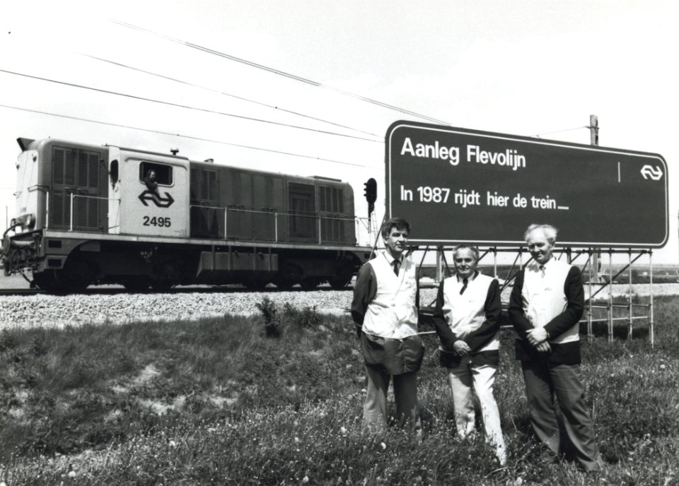 HUA-170868-Groepsportret van de projectleiders voor de aanleg van de Flevolijn, vermoedelijk tussen Muiderberg en Almere, met van links naar rechts ir. J.C. van Hasselt (projectmanager Flevolijn), ing. P.J. van 