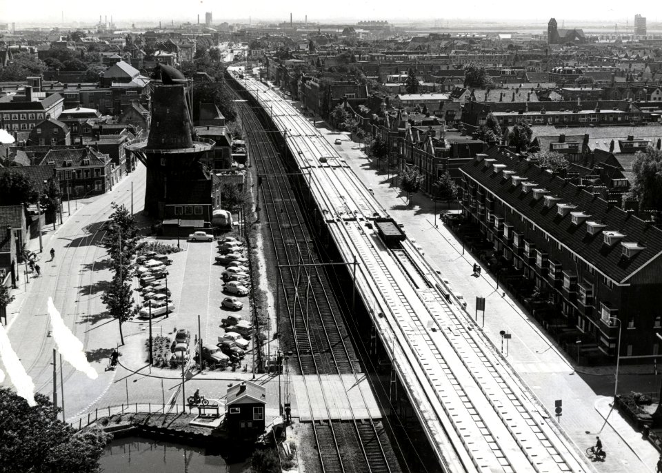 HUA-169112-Overzicht van de spoorlijn door Delft vanaf het Bacinol gebouw van de Gist en Spiritusfabriek aan de Wateringsevest met het oude lage spoortracé en re