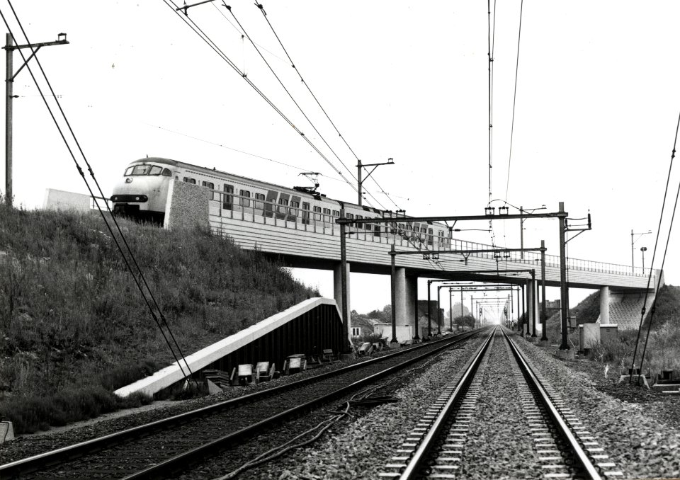 HUA-169183-Gezicht op de nieuwe fly-over voor de spoorlijn richting Rhenen over de spoorlijn Utrecht-Arnhem bij De Haar aansluiting, met twee gekoppelde electrische treinstellen mat. 1964 (plan V) op weg richtin
