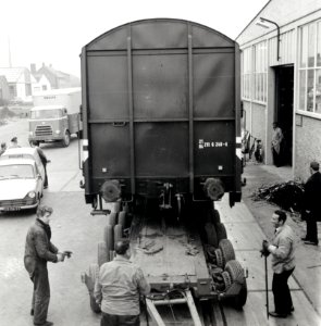 HUA-168091-Afbeelding van het vervoer van een goederenwagen van de N.S. op een oplegger van een vrachtauto ("wagon trailer" of "rolwagenvervoer") te Eindhoven