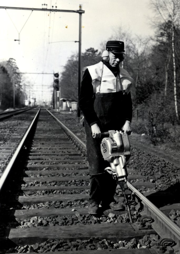 HUA-169037-Afbeelding van een wegwerker van de N.S. met een trilstand tijdens onderhoudswerkzaamheden aan de spoorlijn nabij Driebergen-Zeist