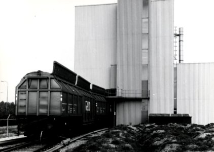 HUA-169073-Gezicht op het overlaadstation voor huisvuil van vrachtauto naar trein van VAM te Apeldoorn, met enkele goederenwagens van VAM Compost
