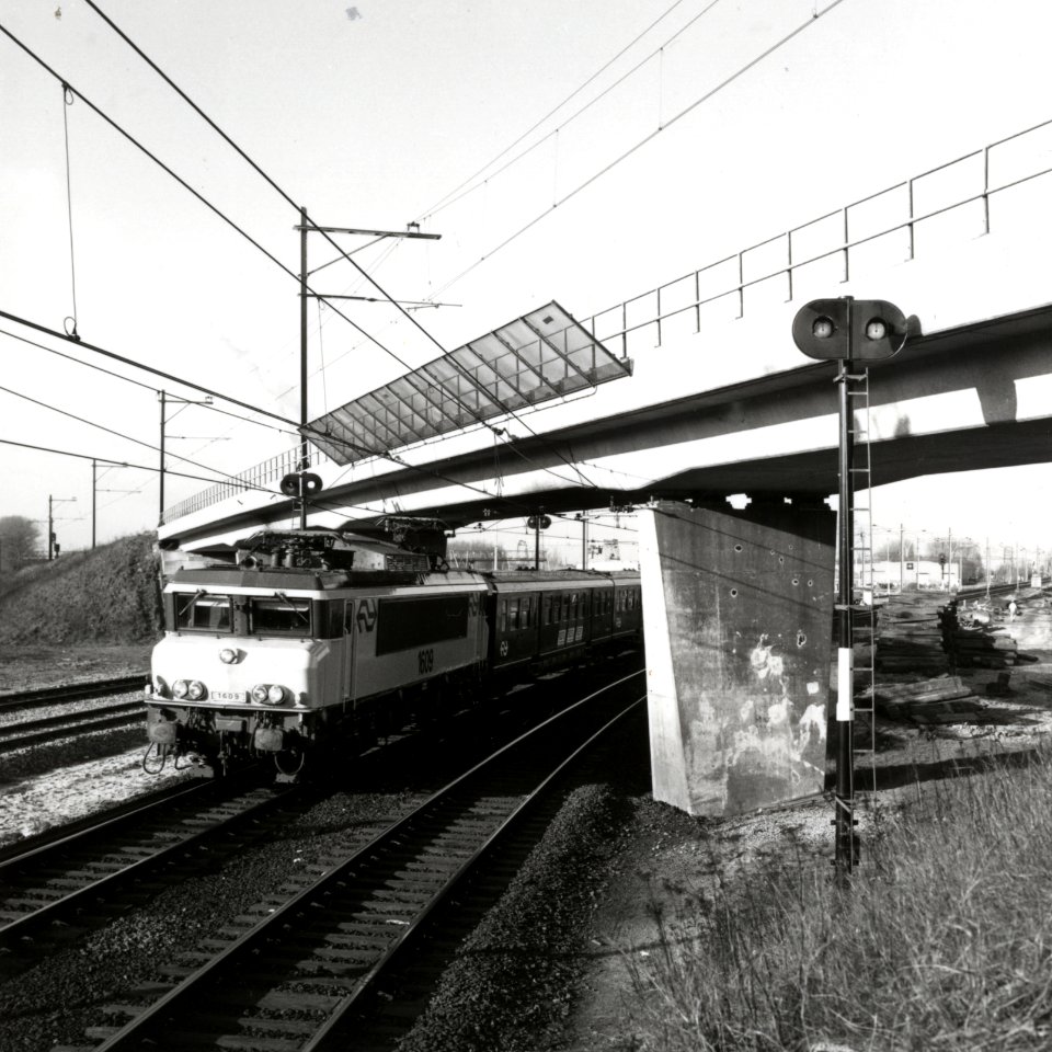 HUA-169176-Afbeelding van de electrische locomotief nr. 1609 (serie 1600) van de N.S. met rijtuigen plan E bij de fly-over aan de noordzijde van het emplacement van het N.S.-station Utrecht C.S. te Utrecht