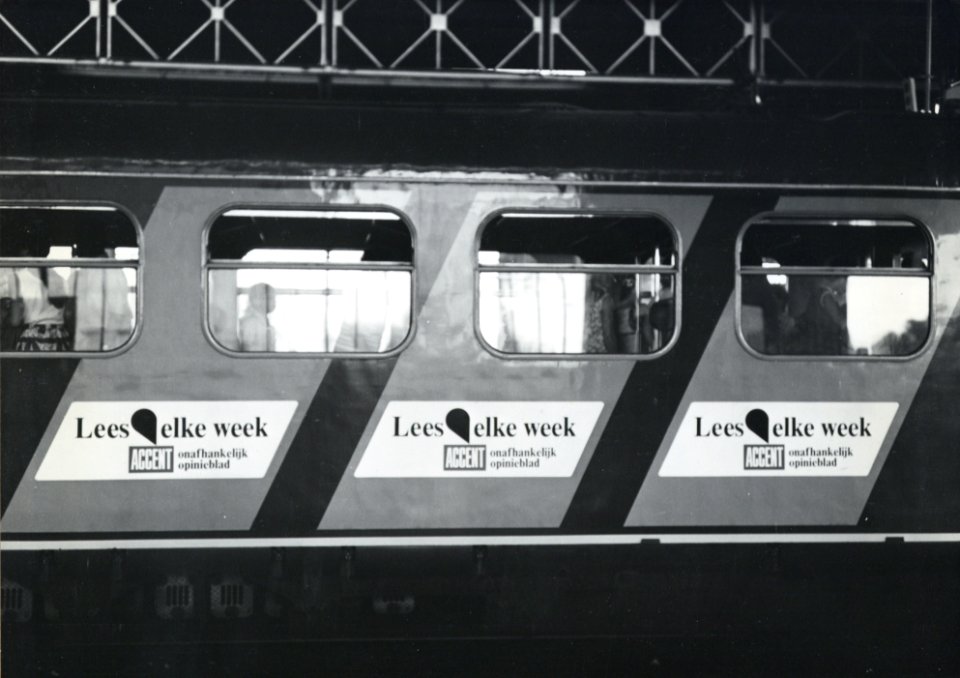 HUA-170713-Afbeelding van de blauwe, diagonale reclamebanden op de zijwand van een treinstel van de N.S., met reclame voor het opinieweekblad Accent