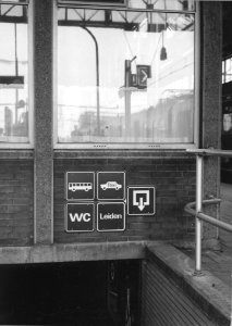HUA-170734-Afbeelding van pictogrammen in de nieuwe huisstijl van N.S. boven de perrontunneltrap van het N.S.-station Leiden