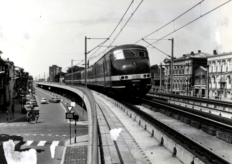 HUA-169116-Afbeelding van een electrisch treinstel mat. 1964 (plan T) van de N.S. op het viaduct van het hoogspoor door Delft