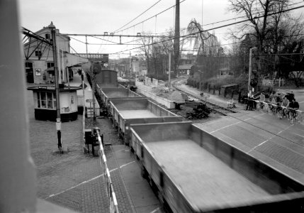 HUA-168891-Gezicht op de spoorwegovergang bij het N.S.-station Driebergen-Zeist te Driebergen-Rijsenburg, vanaf het seinhuis, tijdens de passage van een goederentrein