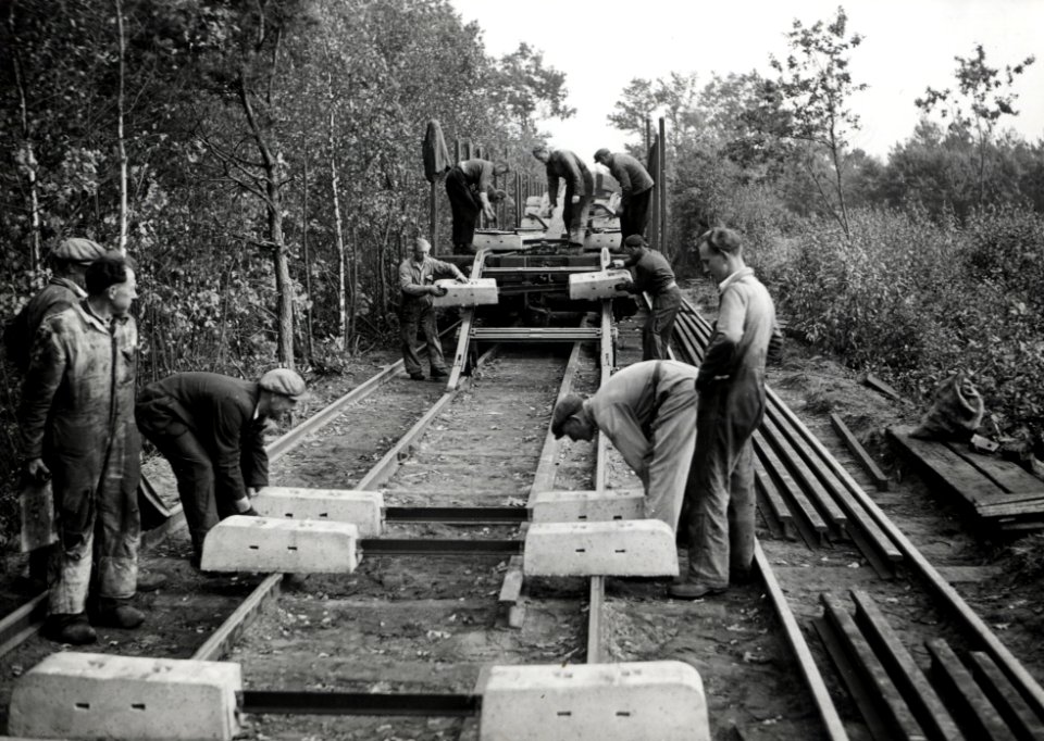 HUA-168953-Afbeelding van wegwerkers van de N.S. tijdens het lossen van betonnen dwarsliggers te Klarenbeek