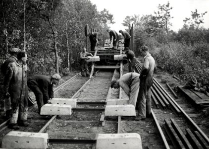 HUA-168953-Afbeelding van wegwerkers van de N.S. tijdens het lossen van betonnen dwarsliggers te Klarenbeek