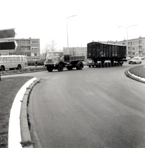 HUA-168096-Afbeelding van het vervoer van een goederenwagen van de N.S. op een oplegger van een vrachtauto ("wagon trailer" of "rolwagenvervoer") te Eindhoven