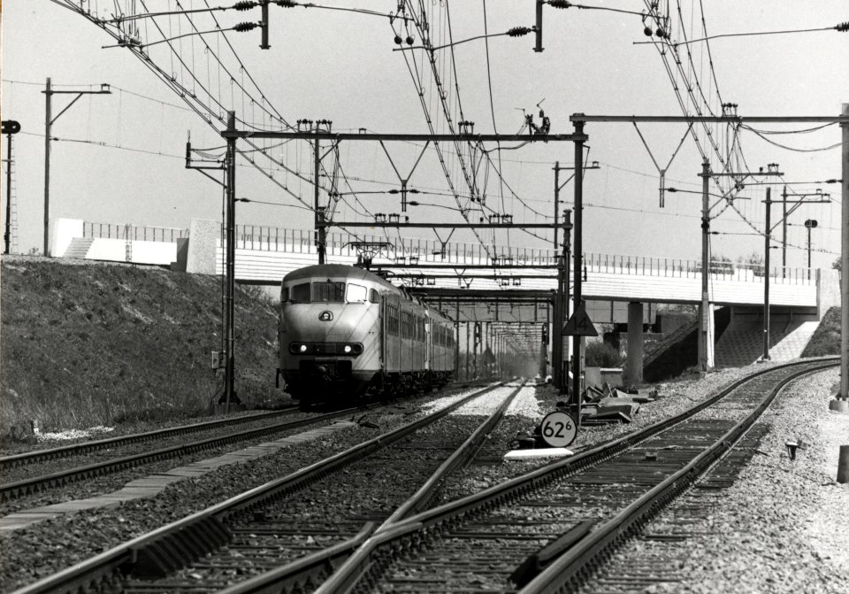 HUA-169182-Gezicht op de nieuwe fly-over voor de spoorlijn richting Rhenen over de spoorlijn Utrecht-Arnhem bij De Haar aansluiting, met twee gekoppelde electrische treinstellen mat. 1964 (plan V) op weg richtin