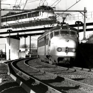 HUA-169169-Afbeelding van twee elkaar kruisende electirsche treinstellen mat. 1954 van de N.S. bij de fly-over aan de noordzijde van het emplacement van het N.S.-station Utrecht C.S. te Utrecht