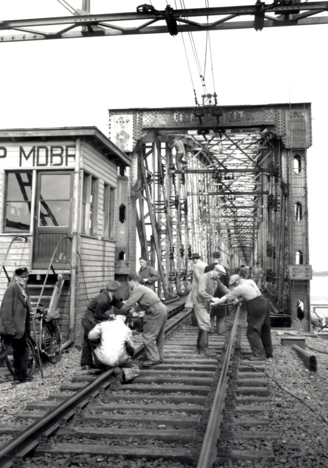 HUA-167986-Afbeelding van de voorbereidende werkzaamheden ten behoeve van het uitvaren van een oud brugdeel van de spoorbrug over het Hollands Diep (Moerdijkbrug) bij Moerdijk, met links de blokpost Moerdijkbrug