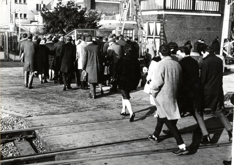 HUA-169226-Afbeelding van bezoekers van de Jaarbeurs te Utrecht die via een tijdelijke uitgang aan de westzijde het station via het dienstoverpad verlaten
