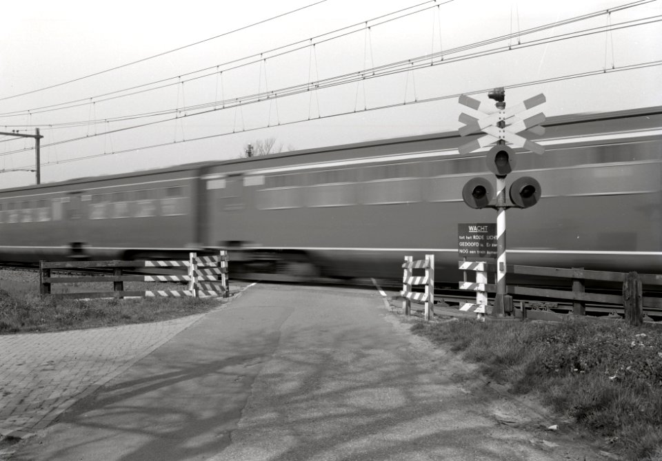 HUA-167628-Afbeelding van een voorbij rijdende trein op de spoorwegovergang in de spoorlijn Utrecht-Amersfoort in de Voordorpsedijk bij Blauwkapel
