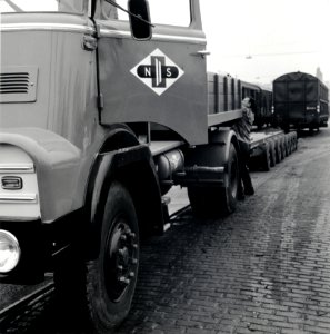 HUA-168106-Afbeelding van het vervoer van een goederenwagen van de N.S. op een oplegger van een vrachtauto ("wagon trailer" of "rolwagenvervoer") te Eindhoven