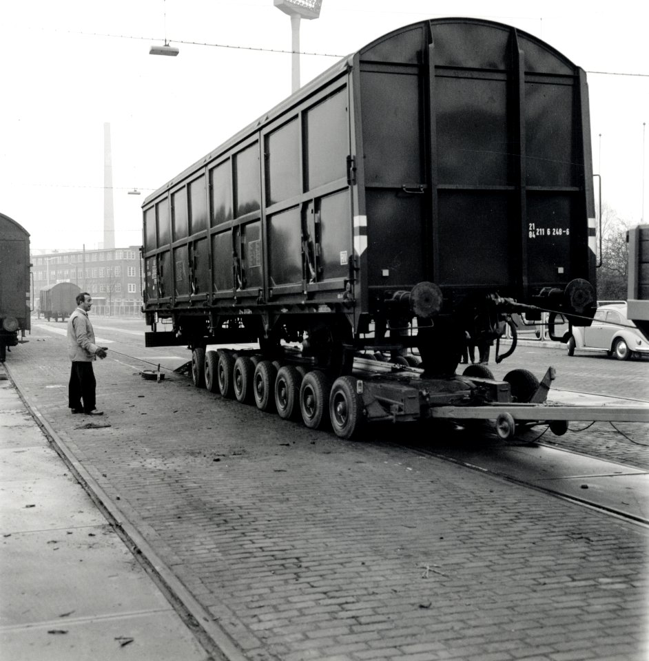 HUA-168093-Afbeelding van het vervoer van een goederenwagen van de NS op een oplegger van een vrachtauto wagon trailer of rolwagenvervoer te Eindhoven