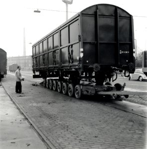 HUA-168093-Afbeelding van het vervoer van een goederenwagen van de NS op een oplegger van een vrachtauto wagon trailer of rolwagenvervoer te Eindhoven