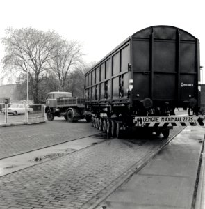 HUA-168094-Afbeelding van het vervoer van een goederenwagen van de NS op een oplegger van een vrachtauto wagon trailer of rolwagenvervoer te Eindhoven