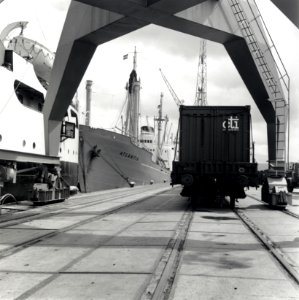 HUA-168443-Afbeelding van een rongenwagen met een container op een kade van de haven te Rotterdam