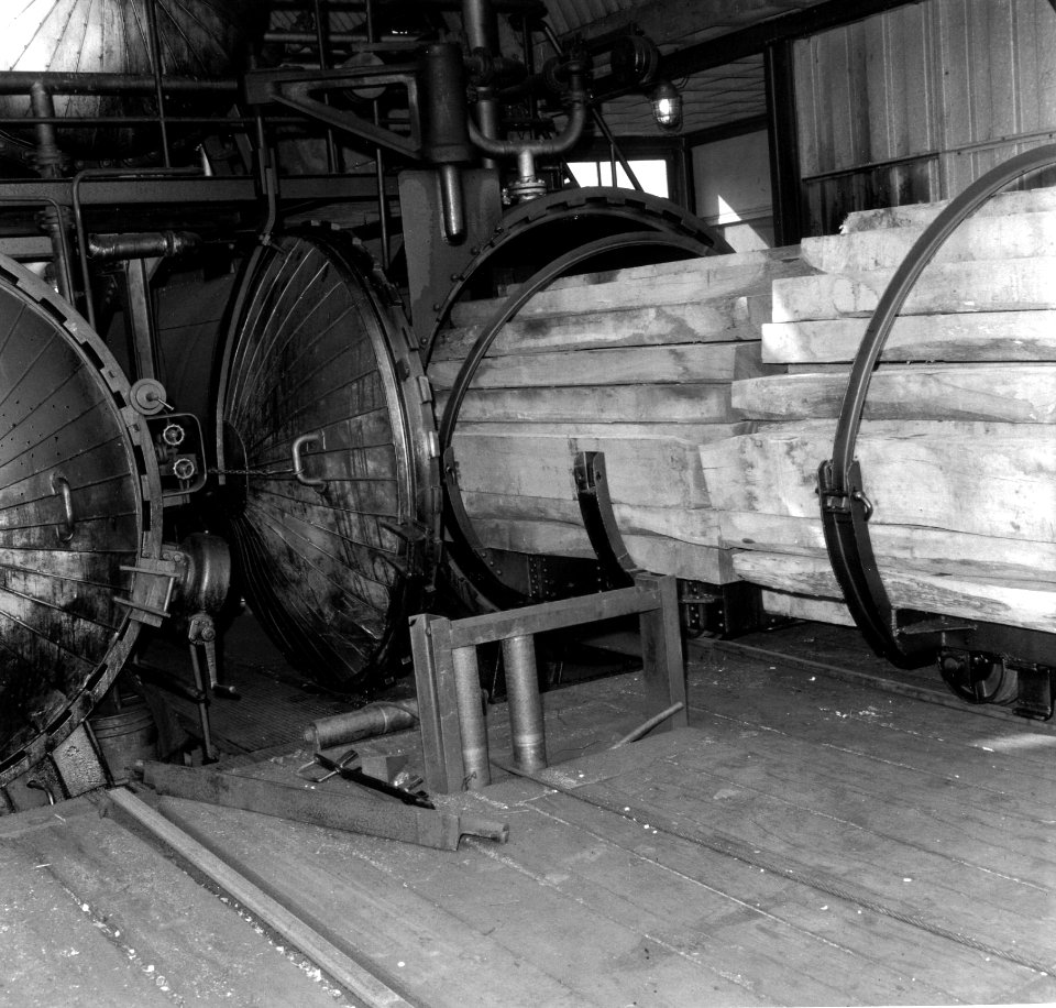 HUA-167674-Afbeelding van het inrijden van onbehandelde dwarsliggers in de autoclaven op het terrein van het Houtbereidingsbedrijf van de N.S. (HBI) te Dordrecht. N.B. In een autoclaaf worden onder vacuümdruk dw