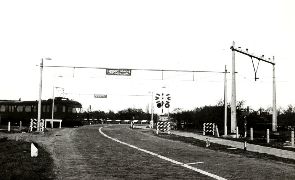 HUA-168775-Afbeelding van de met AHOB's beveiligde spoorwegovergang te Wijnvoorden (tussen Wijhe en Zwolle), tijdens het passeren van een electrische treinstel mat. 1946 van de N.S