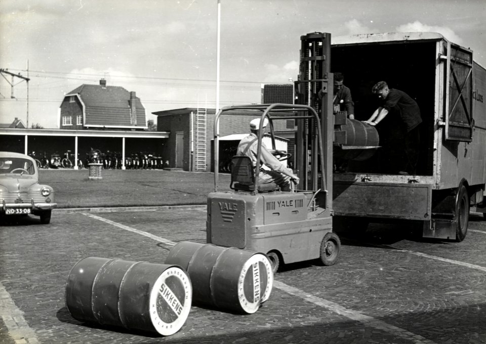 HUA-168350-Afbeelding van het overladen van goederen van lakfabriek Sikkens door Van Gend & Loos, met behulp van een heftruck, te Leiden