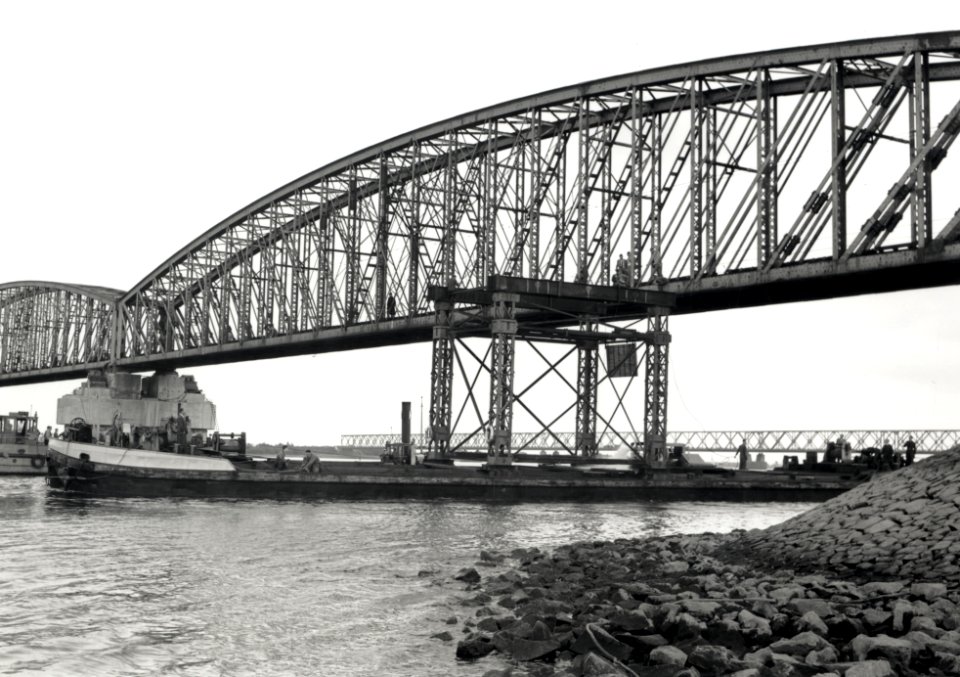 HUA-168006-Afbeelding van het uitvaren van een oud brugdeel van de spoorbrug over het Hollands Diep Moerdijkbrug bij Moerdijk Op achtergrond de verkeersbrug