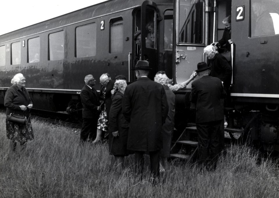 HUA-168828-Afbeelding van een groep bejaarden tijdens het uitstappen uit de extra trein, bestaande uit rijtuigen plan D van de N.S., voor de reis van "Ouden van Dagen" te Harderwijk Haven