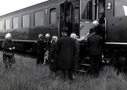 HUA-168828-Afbeelding van een groep bejaarden tijdens het uitstappen uit de extra trein, bestaande uit rijtuigen plan D van de N.S., voor de reis van "Ouden van Dagen" te Harderwijk Haven