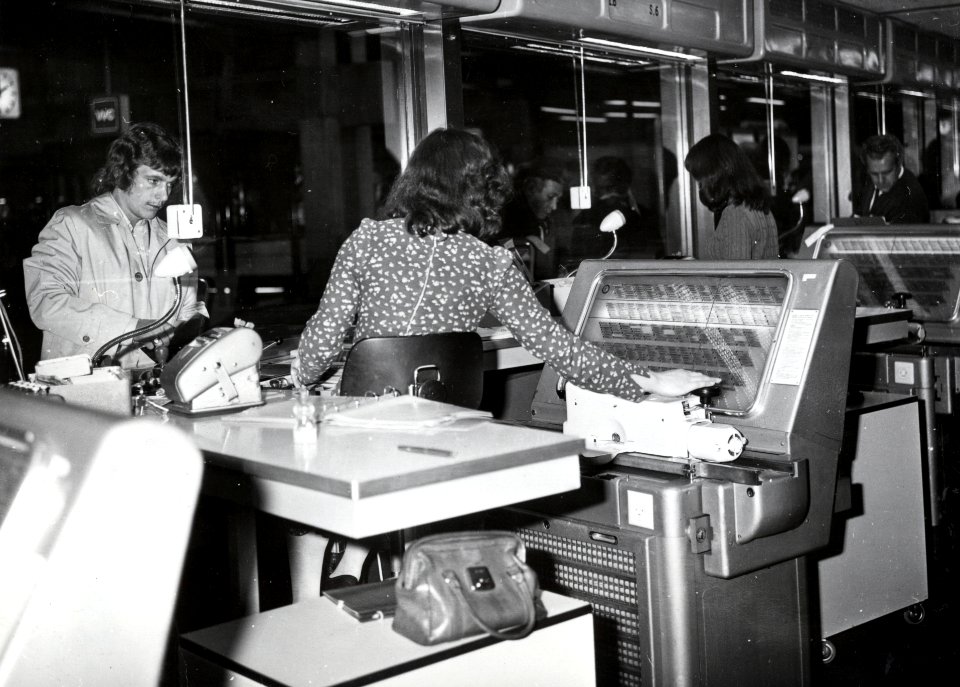 HUA-168521-Interieur van het N.S.-station Utrecht C.S. te Utrecht- plaatskaartenkantoor, met lokettiste bij een A.E.G. - plaatskaartendrukmachine