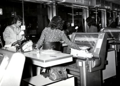 HUA-168521-Interieur van het N.S.-station Utrecht C.S. te Utrecht- plaatskaartenkantoor, met lokettiste bij een A.E.G. - plaatskaartendrukmachine