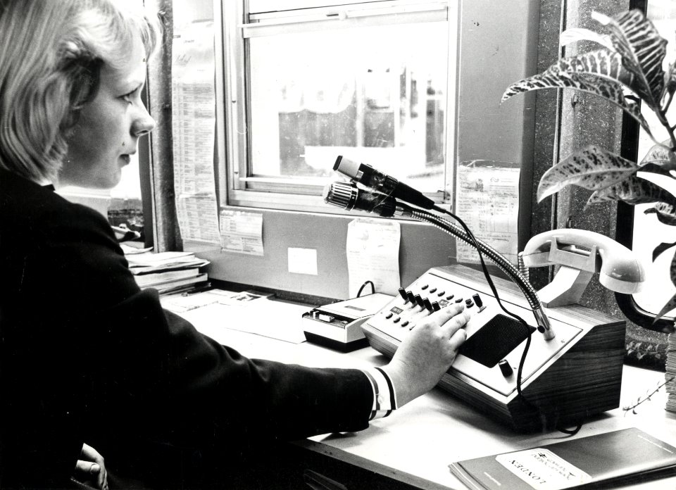 HUA-169315-Afbeelding van een informatrice met telecominstallatie in de hal van het NS station Den Haag CS te Den Haag