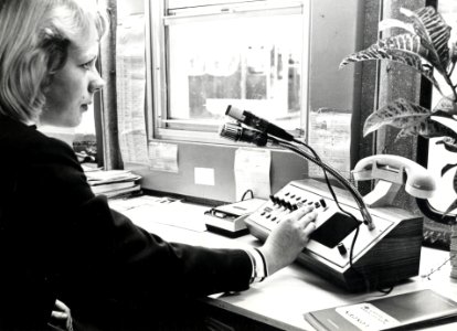 HUA-169315-Afbeelding van een informatrice met telecominstallatie in de hal van het NS station Den Haag CS te Den Haag