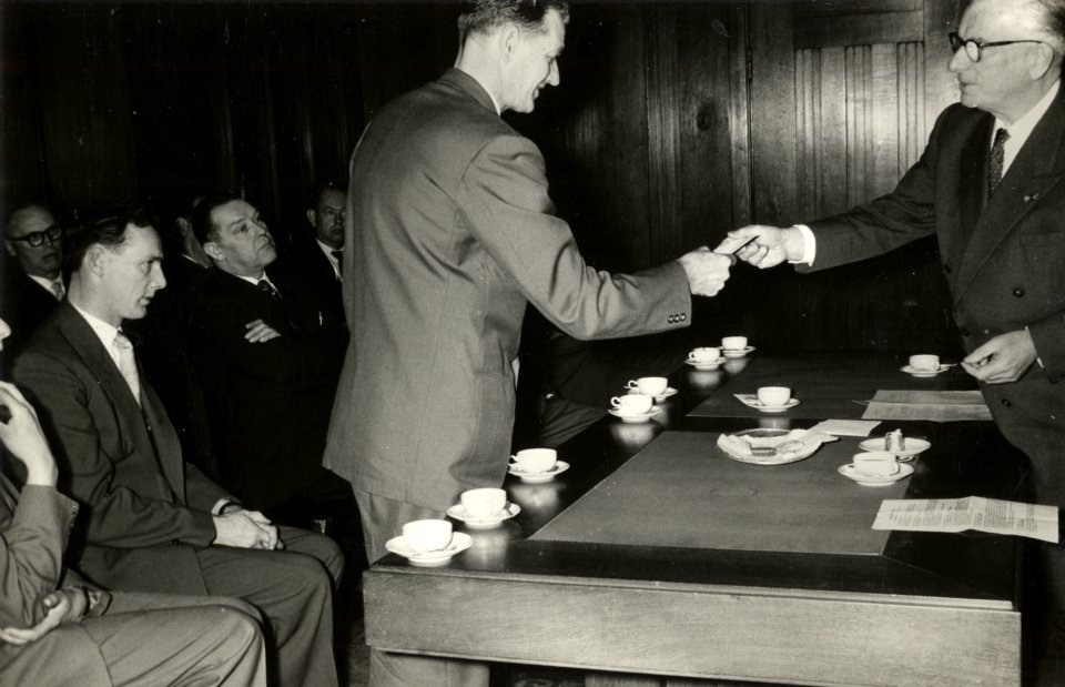 HUA-168772-Afbeelding van de overhandiging van een prijs van fl. 25.- door president-directeur dr. ir. F.Q. den Hollander van de N.S. aan onderladingmeester J. Groot uit Amsterdam Rietlanden. Groot ontving de pr