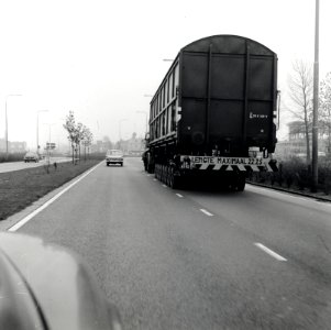 HUA-168103-Afbeelding van het vervoer van een goederenwagen van de N.S. op een oplegger van een vrachtauto ("wagon trailer" of "rolwagenvervoer") te Eindhoven