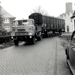 HUA-168101-Afbeelding van het vervoer van een goederenwagen van de N.S. op een oplegger van een vrachtauto ("wagon trailer" of "rolwagenvervoer") te Eindhoven