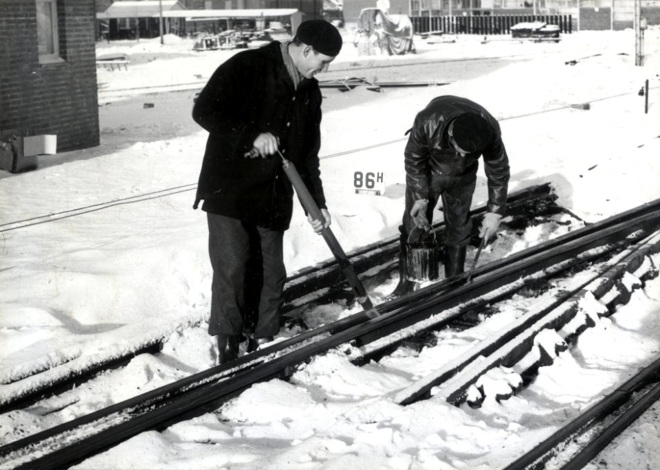 HUA-169540-Afbeelding van twee wegwerkers van de NS tijdens het ontdooien van een vastgevroren wissel op het emplacement van het NS station Utrecht CS te Utrecht