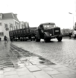 HUA-168037-Afbeelding van een vrachtauto van de Deutsche Bundesbahn (D.B.) met een aanhangwagen waarop een spoorwagon (rongenwagen) vervoerd wordt ("Strassenroller") te Wormerveer