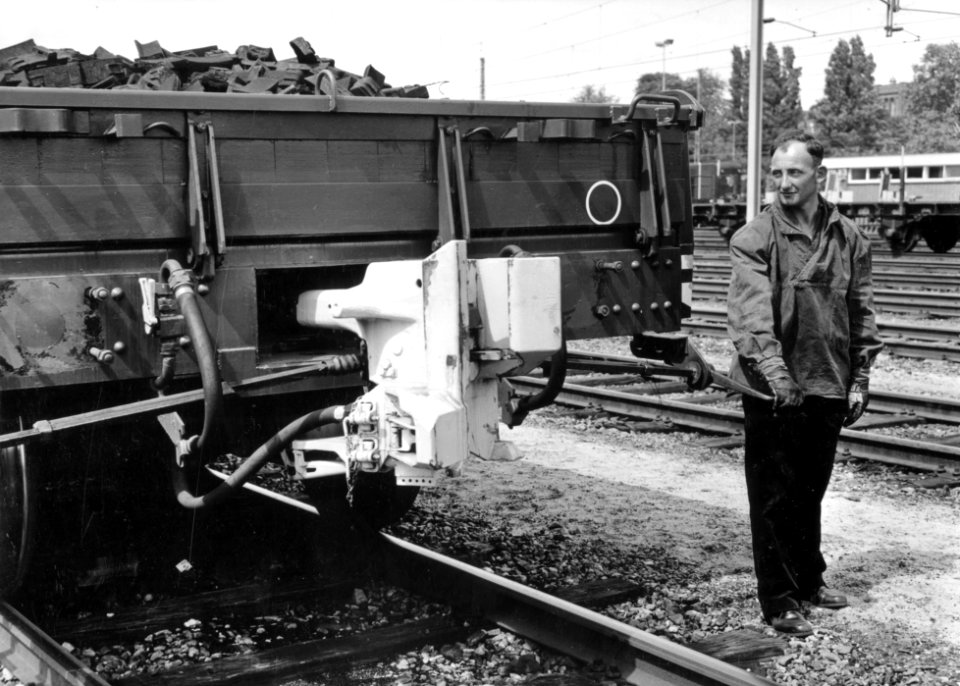 HUA-169511-Afbeelding van een rangeerder van de N.S. bij een proeftrein met goederenwagens voorzien van een automatische koppeling te Utrecht