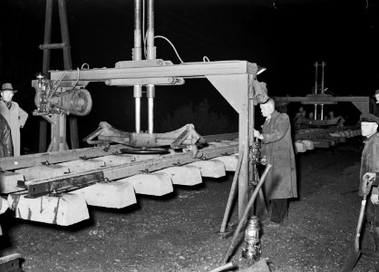 HUA-168955-Afbeelding van het leggen van spoor met betonnen dwarsliggers te Klarenbeek bij nacht