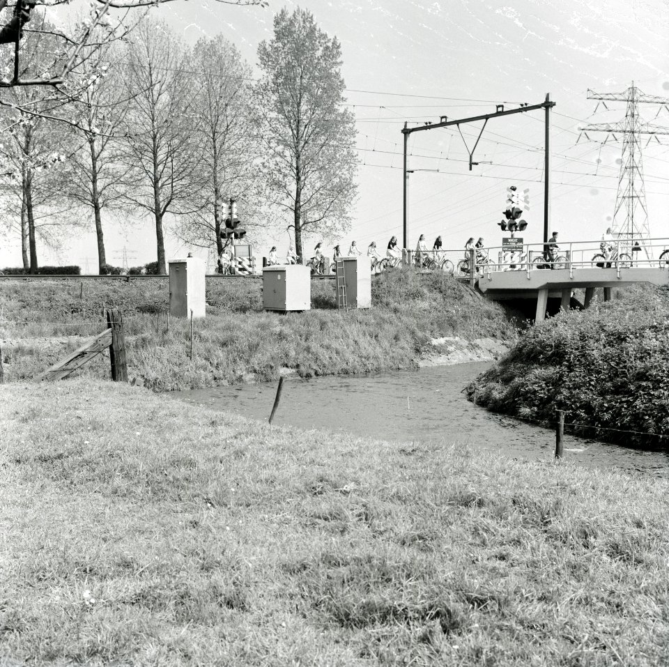 HUA-167634-Gezicht op de spoorwegovergang bij de Fortweg - Mereveldseweg te Houten, met een groep fietsende kinderen